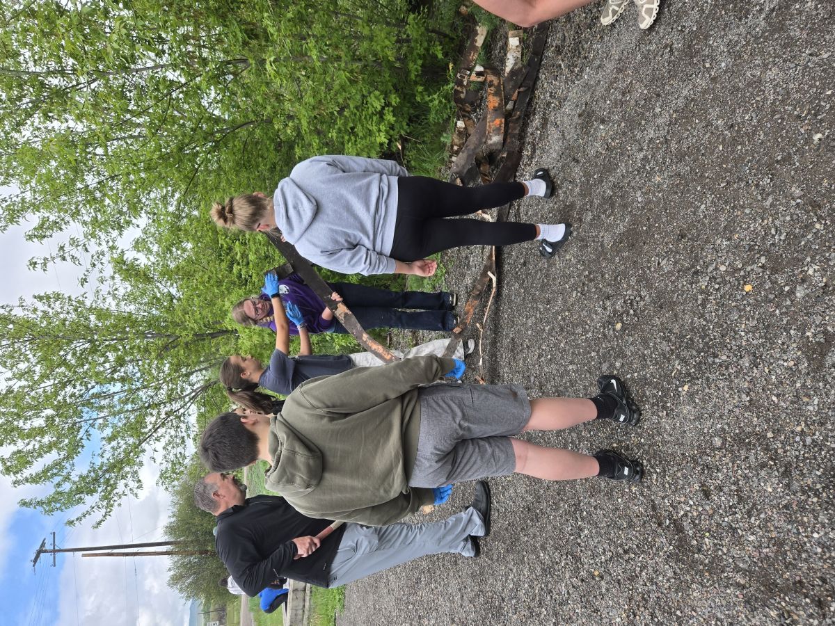 students planning cleanup efforts in front of green trees